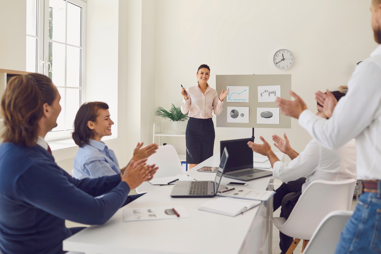 Happy Employees Celebrating Sales Increase in Corporate Meeting with Sales Manager